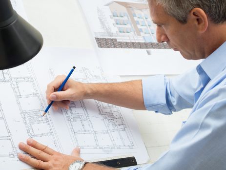 Architect Working At Drawing Table